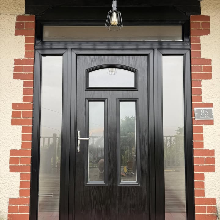 A recently installed black composite front door with matching glazed side panels